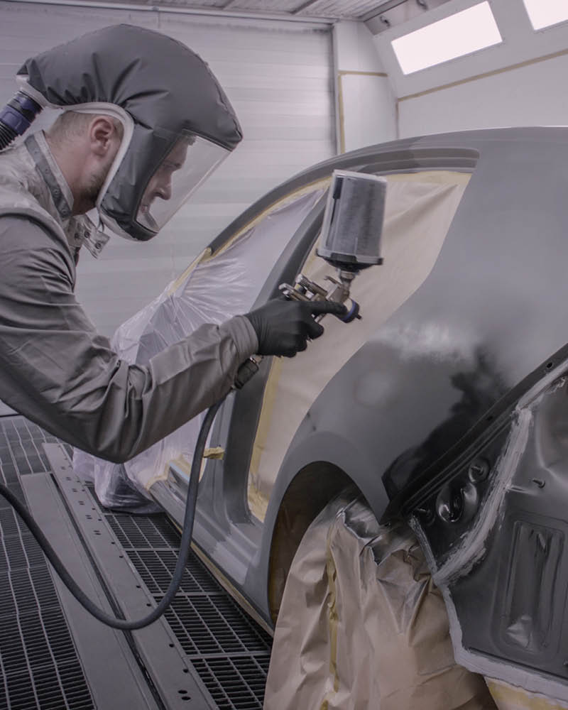 Mitarbeiter lackiert ein Auto