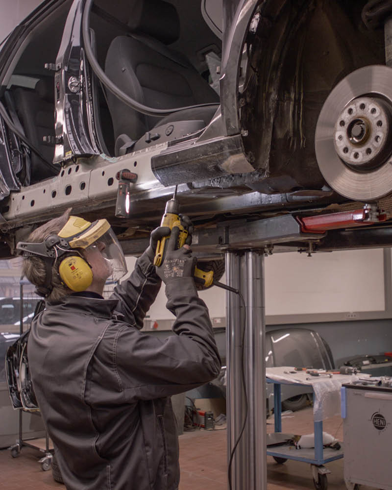 Mitarbeiter bohrt an einem Auto